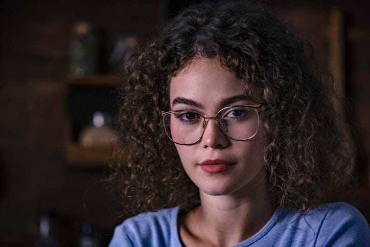 woman with glasses looking serious