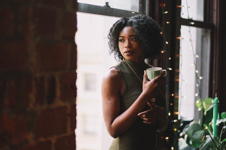 african american woman leaning against a window