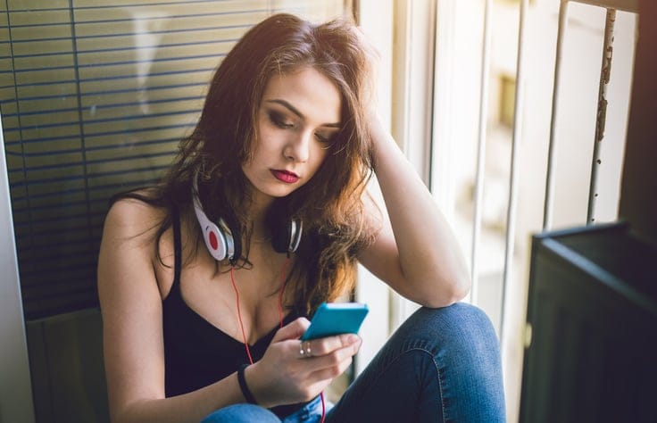 woman with headphones texting