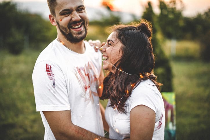 couple laughing together in a field