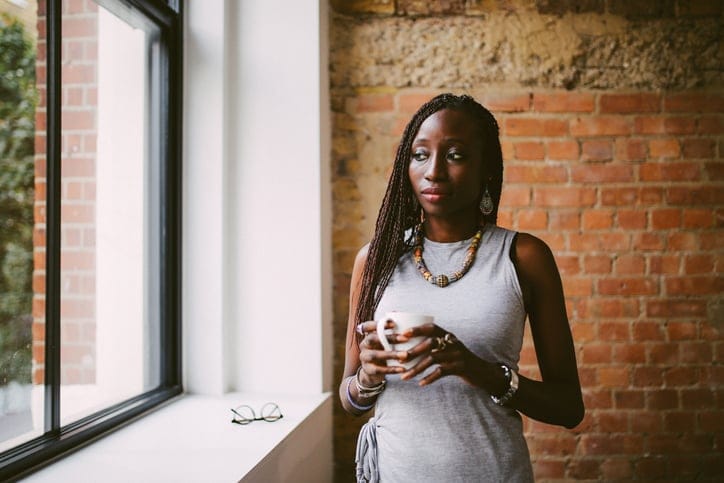black woman standing beside a window