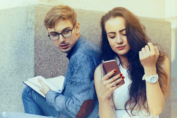 man looking over woman's shoulder