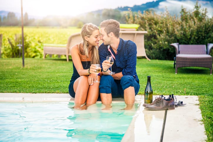 couple kissing by a pool