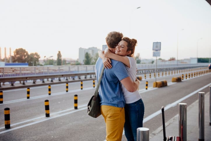Couple hugging at the airport.