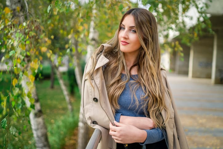 young woman leaning against a wall
