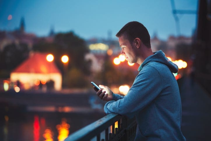 man texting at night in the city