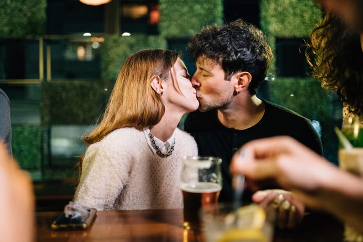 couple kissing at a bar
