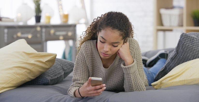 african american girl looking at her mobile