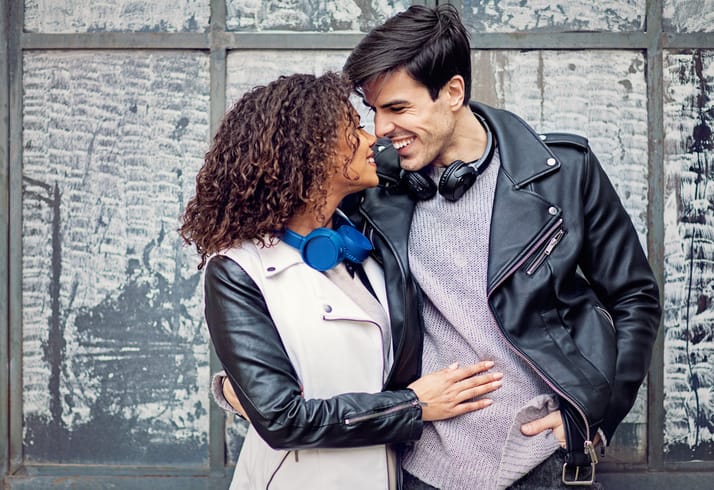 couple wearing headphones smiling