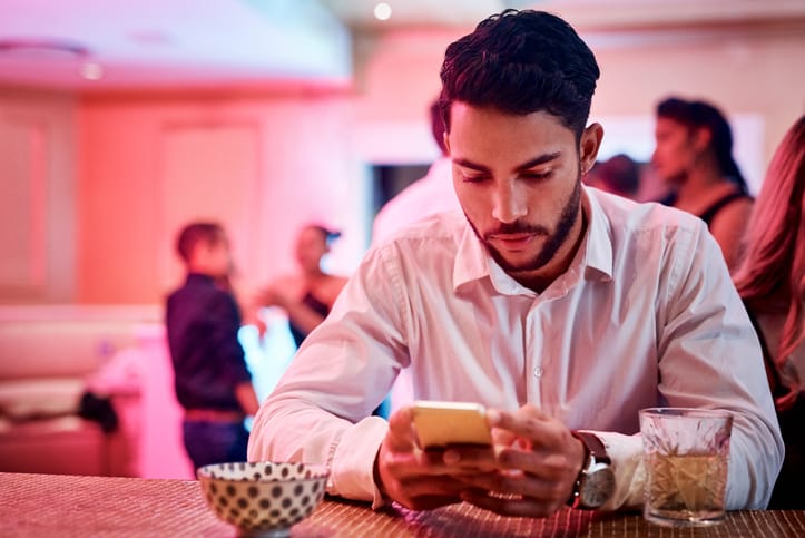 man texting in a bar