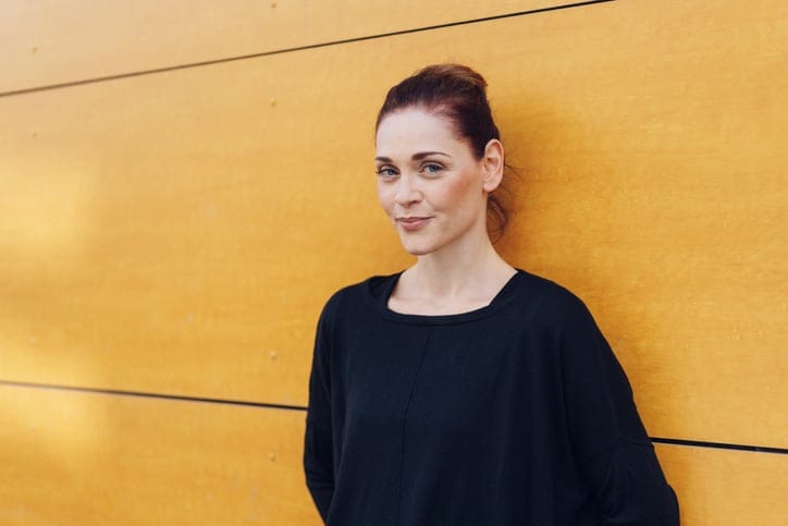 woman standing against a yellow wall
