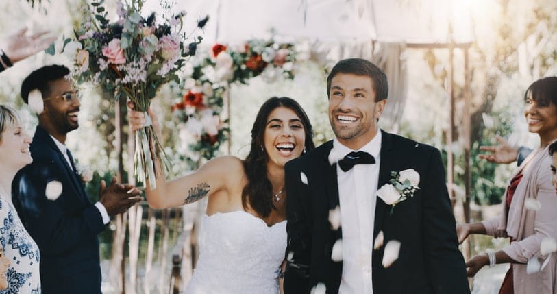 Cropped shot of a beautiful young bride holding up her bouquet while standing next to her groom on their wedding day