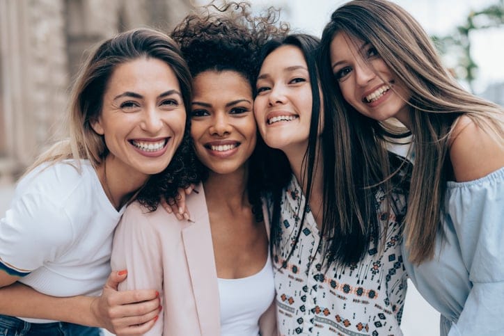 four female friends hugging.