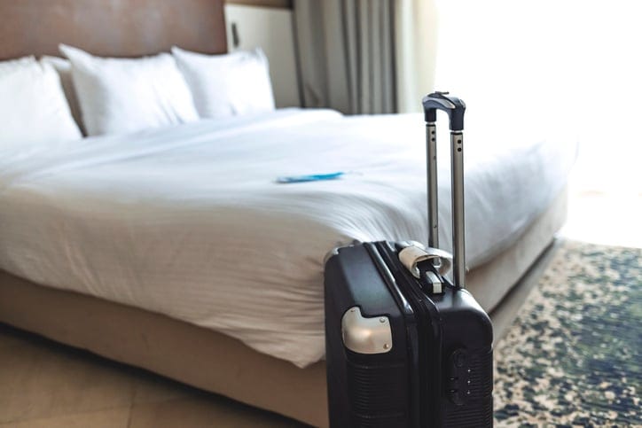 Black suitcase in a hotel room.