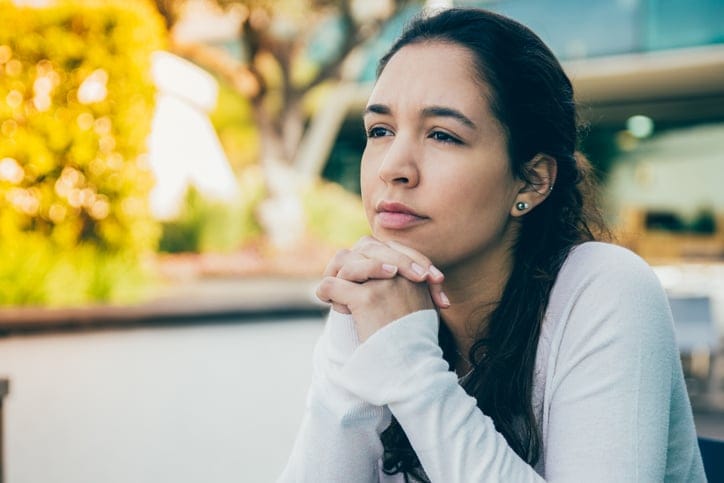 thoughtful woman sitting outside