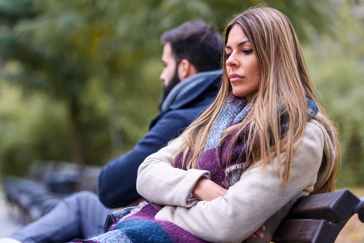 Couple sitting in park having relationship problems.
