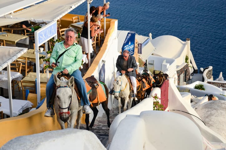 Tourists riding donkeys in Greece.