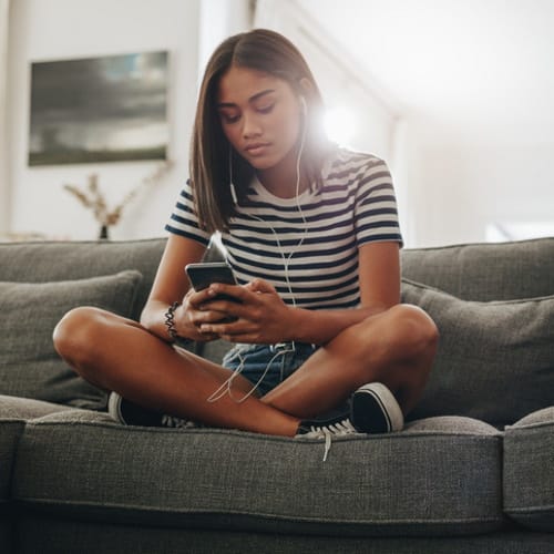 woman sitting texting on the sofa