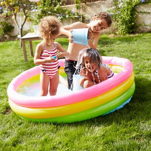 three kids in a paddling pool