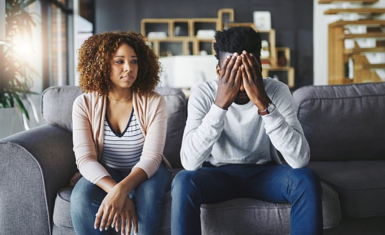 Unhappy couple sitting on the couch.