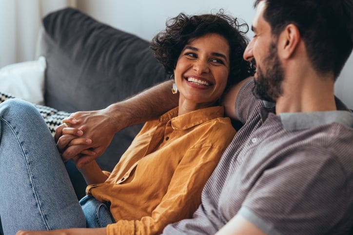 Couple cuddling on the couch.