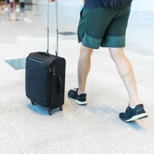 Man rolling his suitcase.