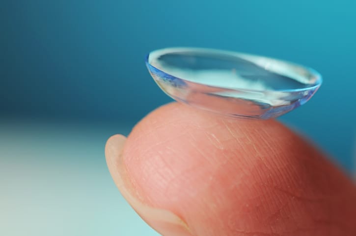 Finger holding a contact lense.