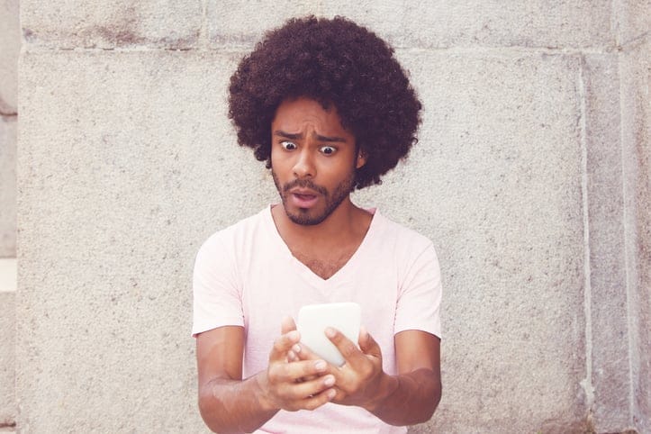 afro american man texting shocked