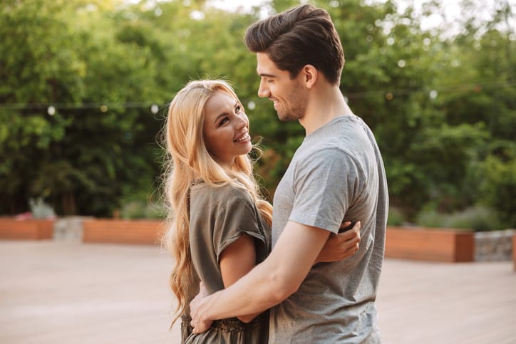 dating a clingy guyBack view of Happy lovely young couple hugging and looking to each other outdoors