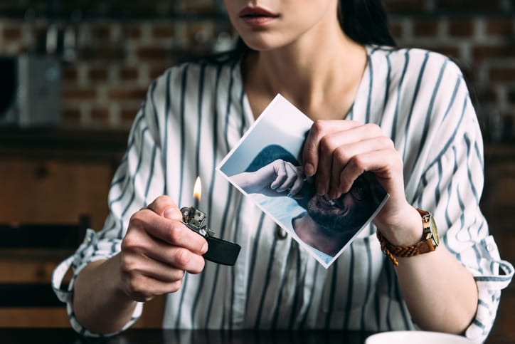Woman burning photo of her ex-boyfriend.