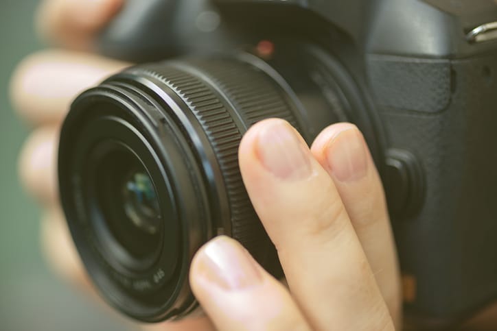 Photographer's hands on a camera.