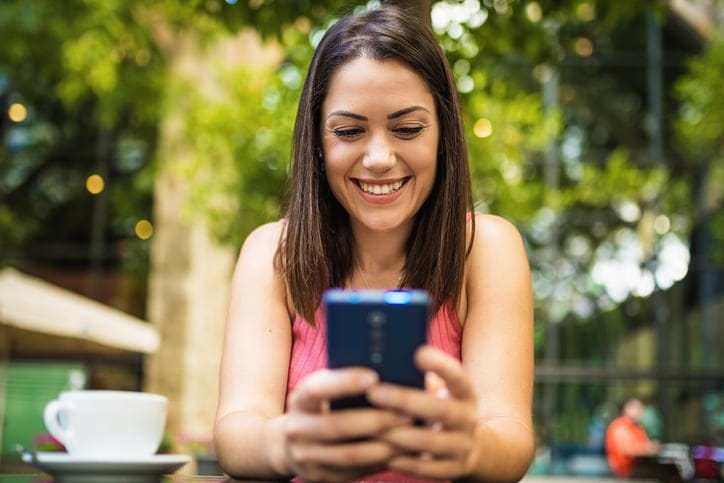 smiling brunette woman texting