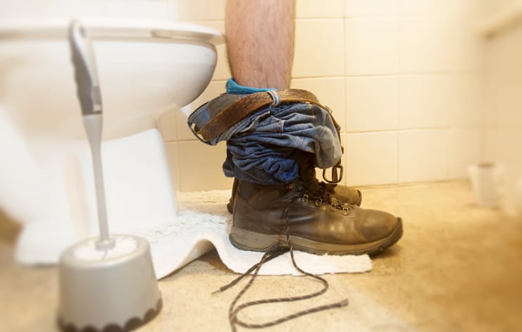 cropped shot of legs on toilet