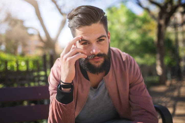 man with beard holding temple