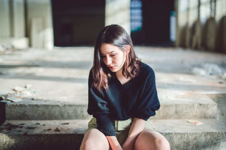 sad woman sitting in bedroom