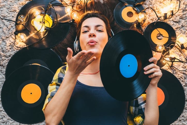Young woman listening to records, lying down.
