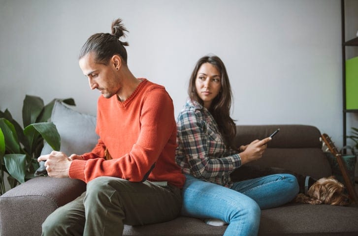 Unhappy couple on their phones.