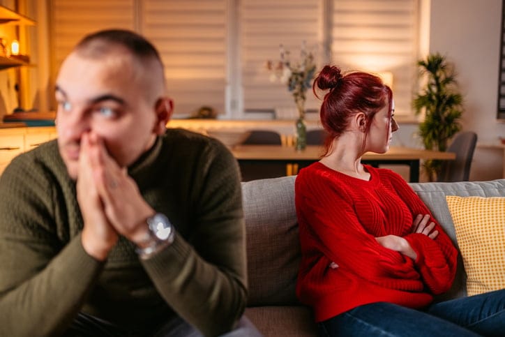 Woman looking away from man in an argument.