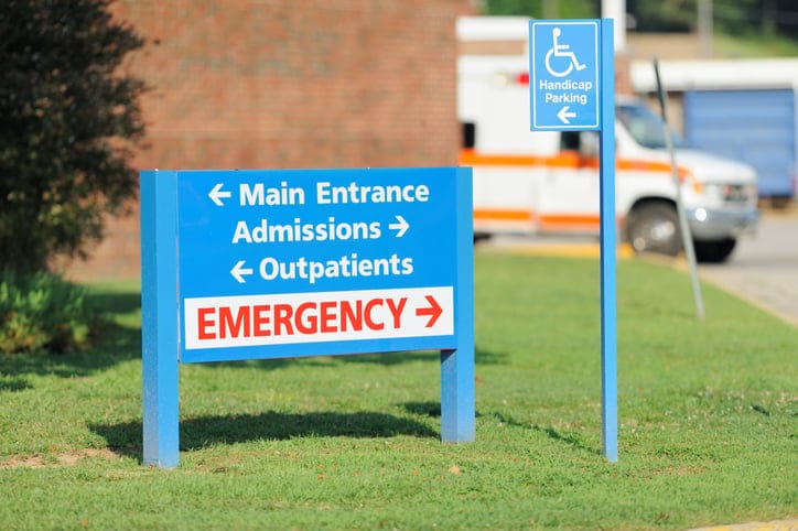 Hospital entrance and emergency sign with ambulance.