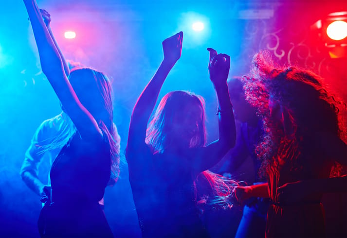 Girlfriends dancing in nightclub.