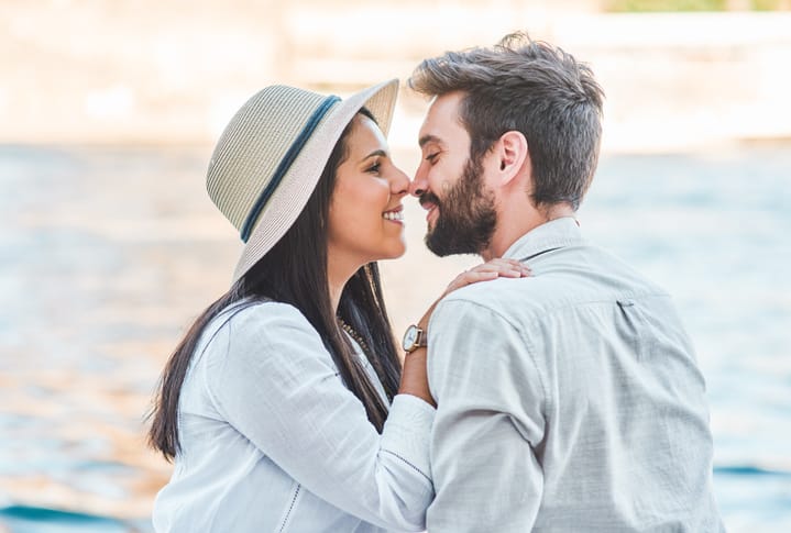 woman hat kissing man