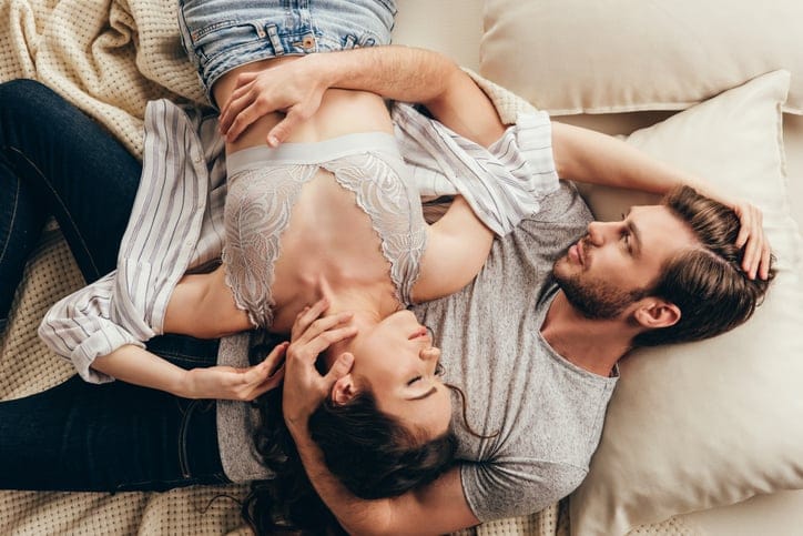 serious couple laying in bed