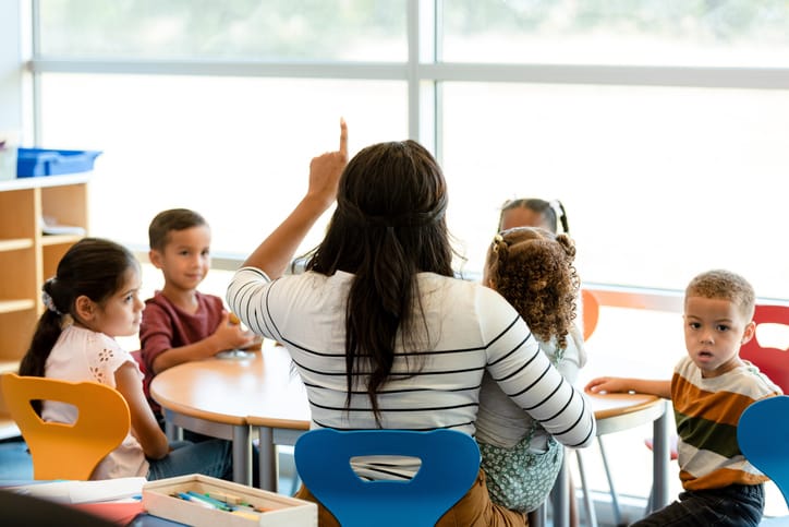 Children and their teacher in the classroom.