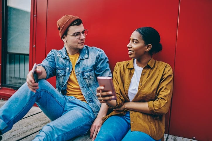flirty couple leaning against wall