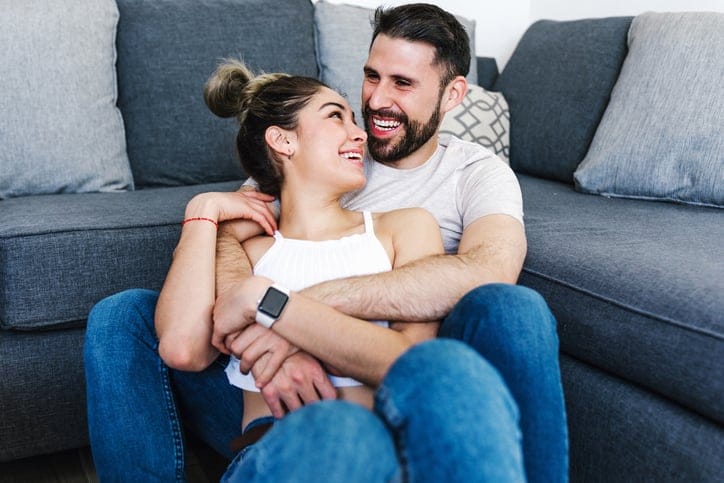 couple cuddling on living room floor