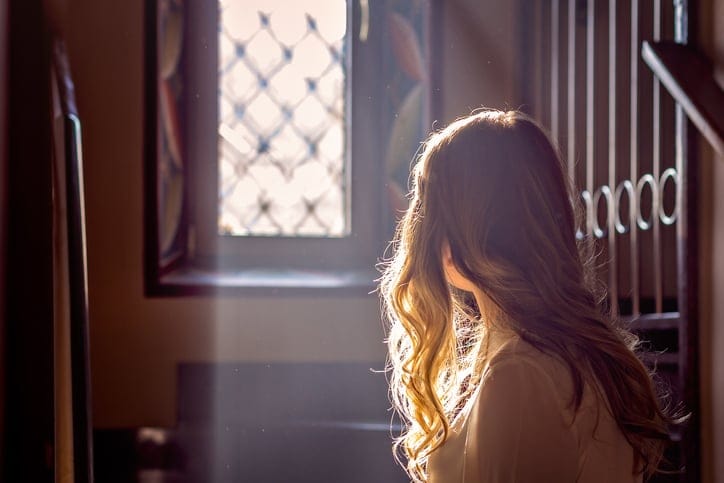 Child looking out the window of a church.