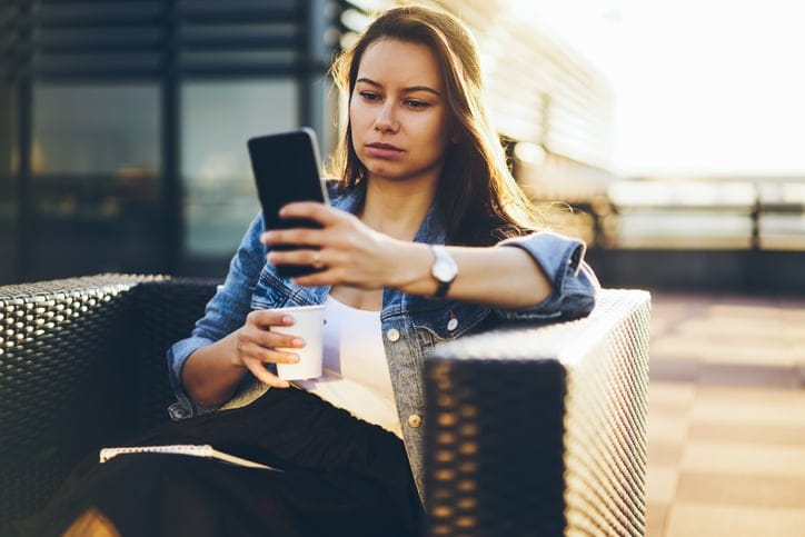 Businesswoman with cup of coffee on phone.