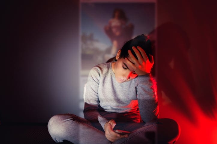 young woman social media depressed bedroom phone