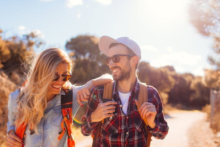 young couple hiking on sunny day