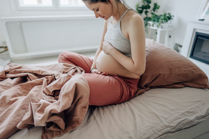 Young expectant mother stroking her baby bump.
